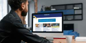 Un homme assis à un bureau consulte une page web intitulée « Formations », présentant trois modules : accompagnement scolaire des élèves en situation de handicap, programmes inclusifs, et inclusion en plein air. Chaque module est illustré par une image descriptive.